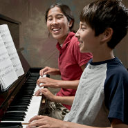 Two kids playing the piano